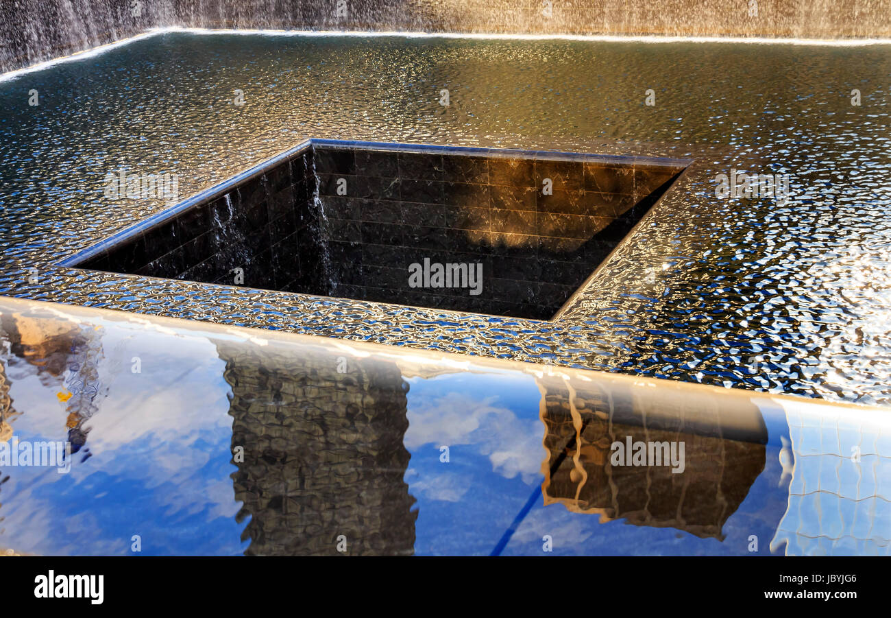 911 Memorial piscina fontana a cascata astratte riflessioni di New York New York. La piscina è nella fondazione di uno dei due World Trade Center edifici. L'acqua cade nel foro della fondazione. Foto Stock