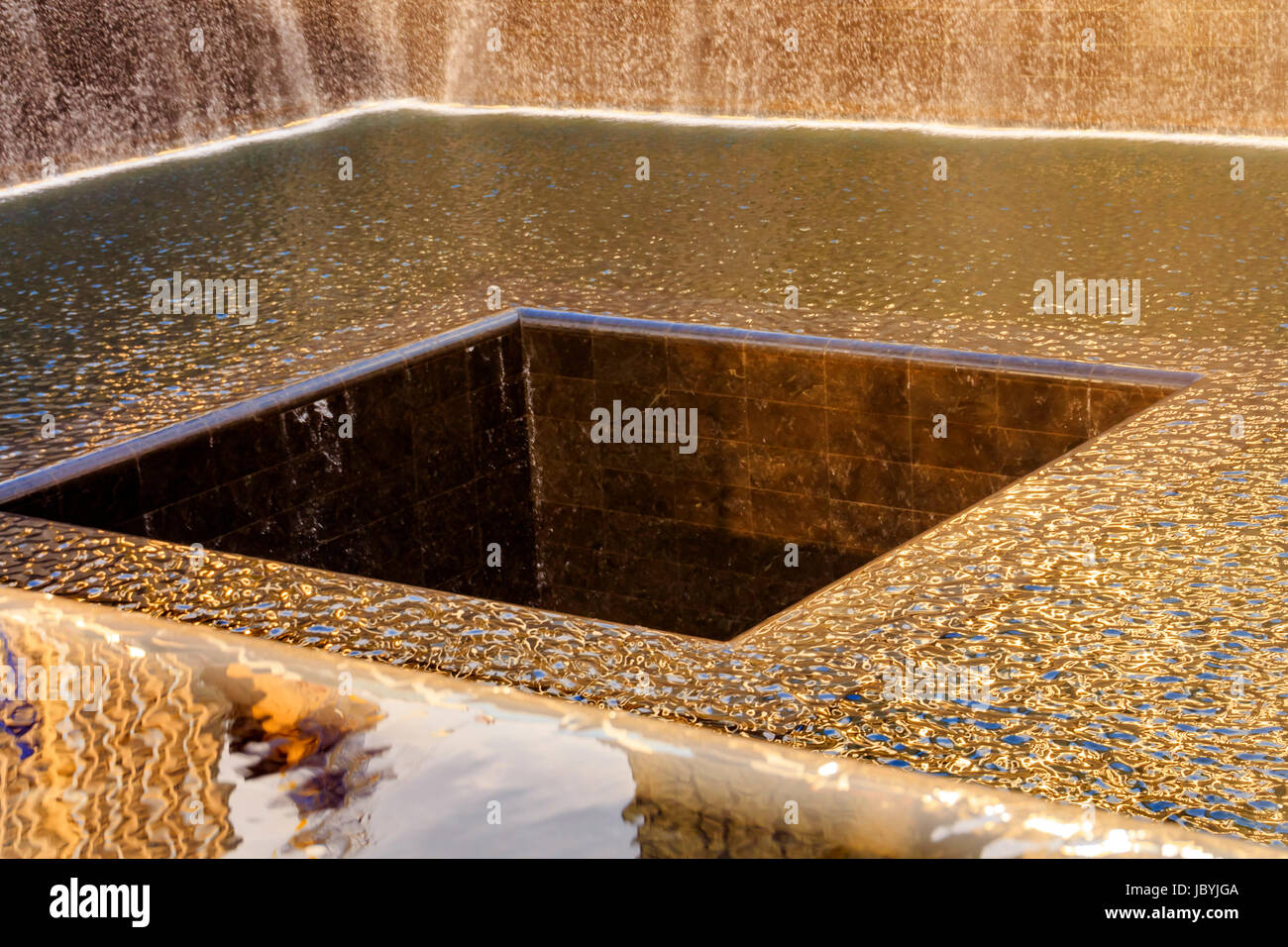 911 Memorial piscina fontana a cascata astratte riflessioni di New York New York. La piscina è nella fondazione di uno dei due World Trade Center edifici. L'acqua cade nel foro della fondazione. Foto Stock