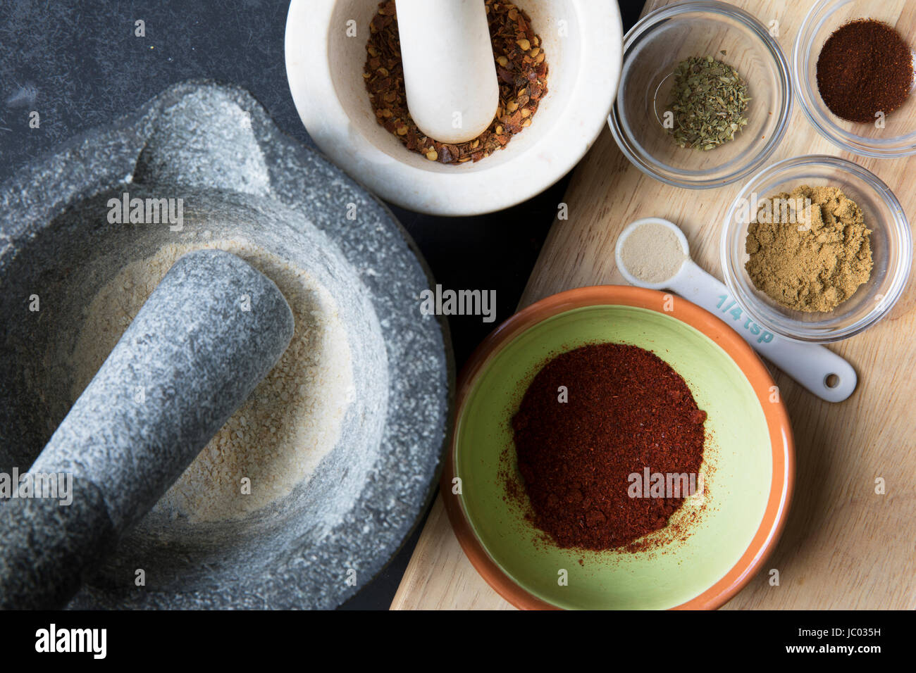 Mortaio e pestello e piccole ciotole con spezie per taco condimento. Foto Stock