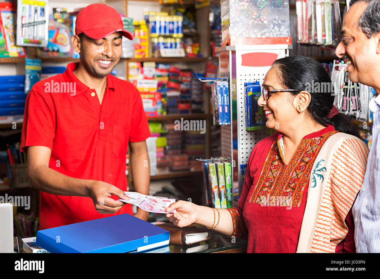Negoziante e cliente dando rupie denaro in shop shopping e commercio al dettaglio Foto Stock