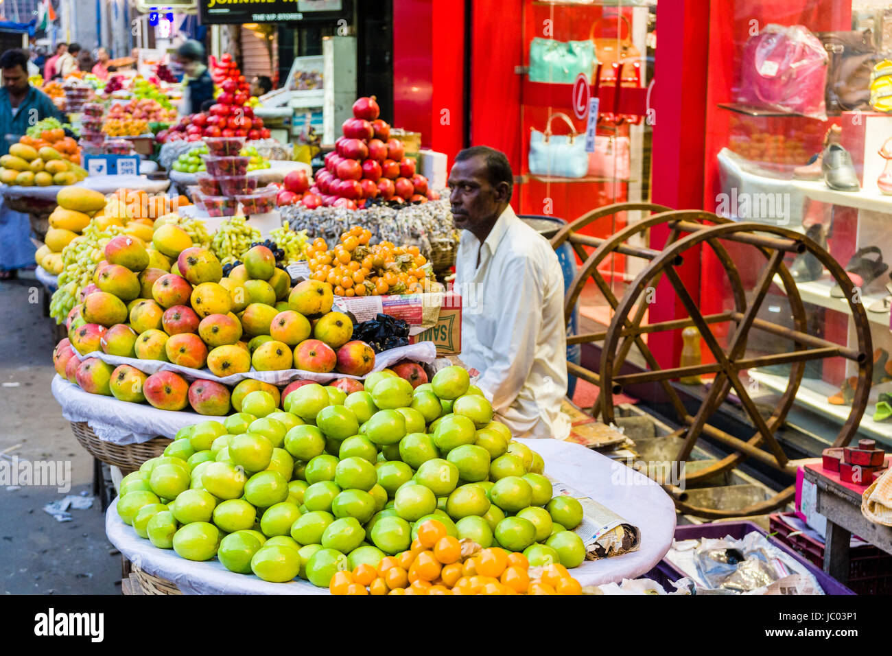 Un uomo è la vendita di frutta in un affollato mercato ortofrutticolo Street nel quartiere nuovo mercato Foto Stock