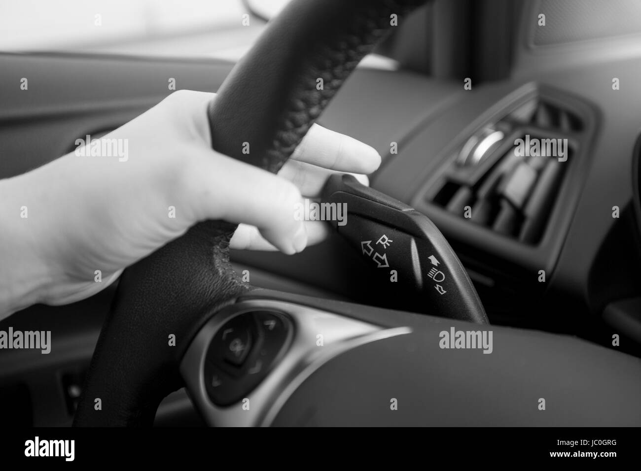 Closeup foto in bianco e nero del driver utilizzando indicatori di direzione Foto Stock