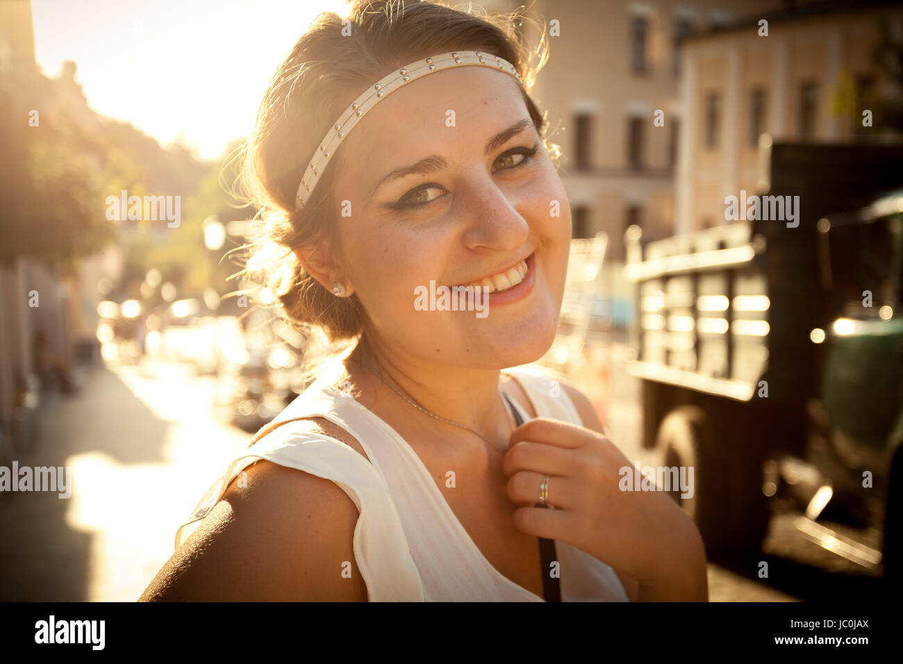 Closeup ritratto di donna sorridente con stile greco haircut su strada in corrispondenza della luce del sole Foto Stock