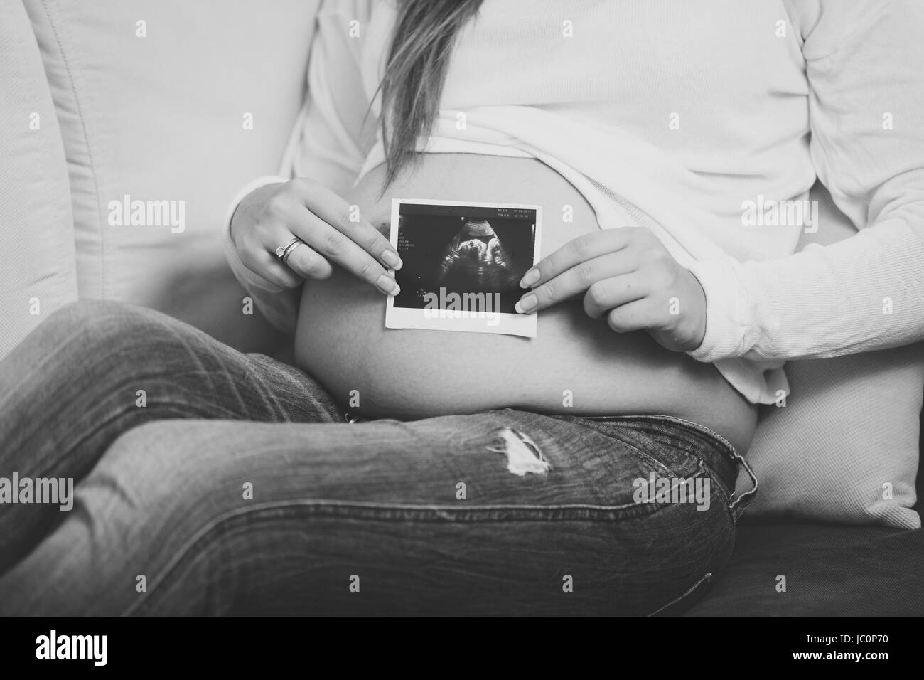 Bianco e nero closeup foto di donna incinta in posa con scansione a ultrasuoni Foto Stock
