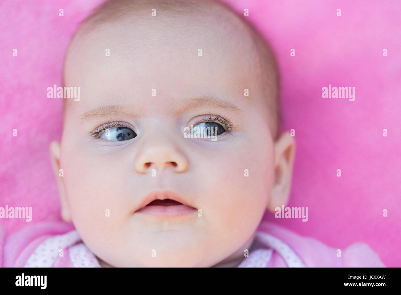 Close up adorabile faccia bambino in rosa di massa posteriore Foto Stock