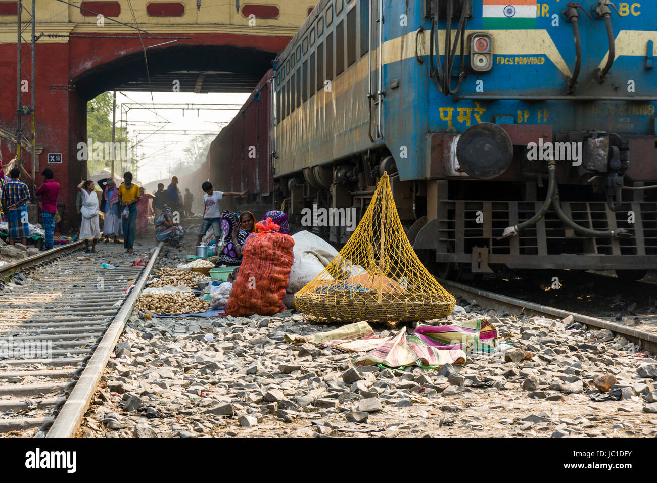 Le donne sono la vendita di spezie e verdure tra i binari della ferrovia  presso il park circus stazione ferroviaria, un treno è passante Foto stock  - Alamy