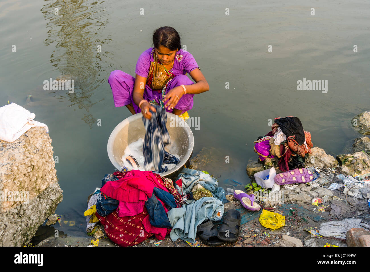 Una donna, dhobi, sta facendo lavanderia a un lago nel sobborgo topsia Foto Stock