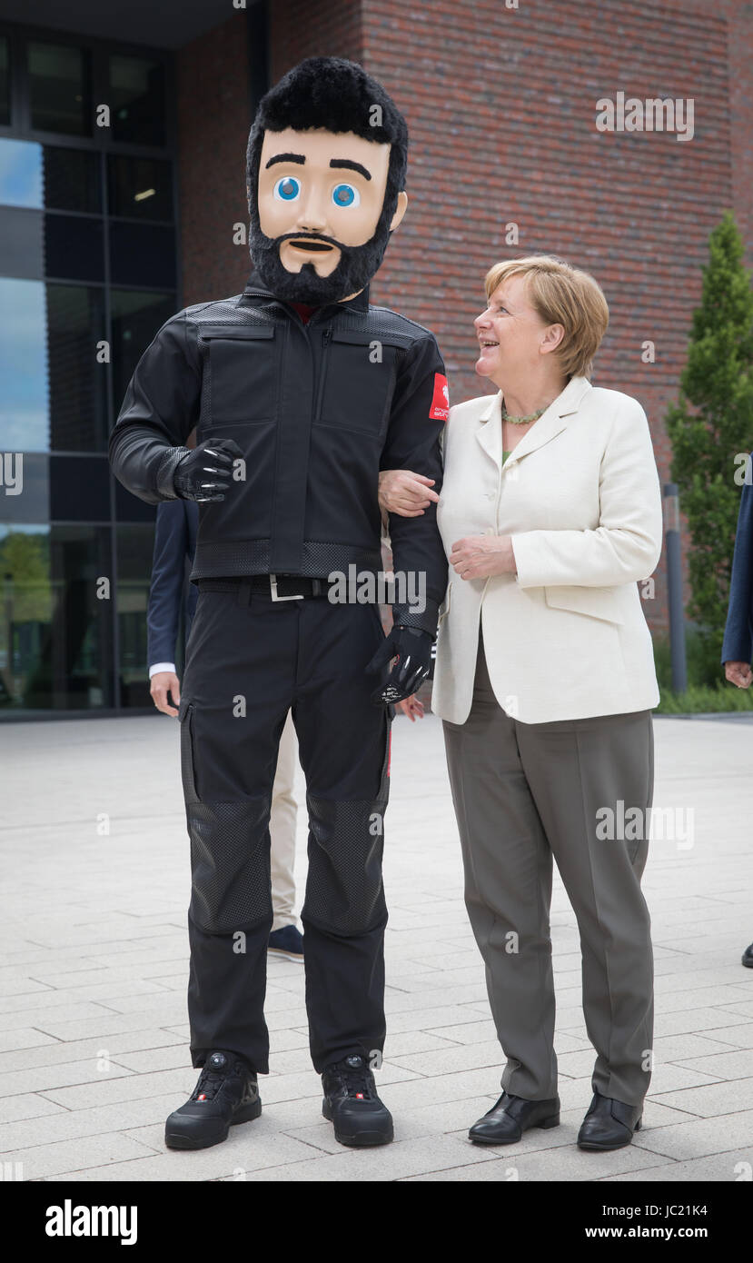 Biebergemund, Germania. Xiii Giugno, 2017. Il cancelliere tedesco Angela Merkel scherzi con la mascotte della società "Luigi' presso il cortile dell'azienda di famiglia Engelbert Strauss in Biebergemund, Germania, 13 giugno 2017. Il cancelliere ha visitato il produttore specializzato di indumenti da lavoro e stato informato sulla sua crescita e i piani per il futuro. Foto: Frank Rumpenhorst/dpa/Alamy Live News Foto Stock