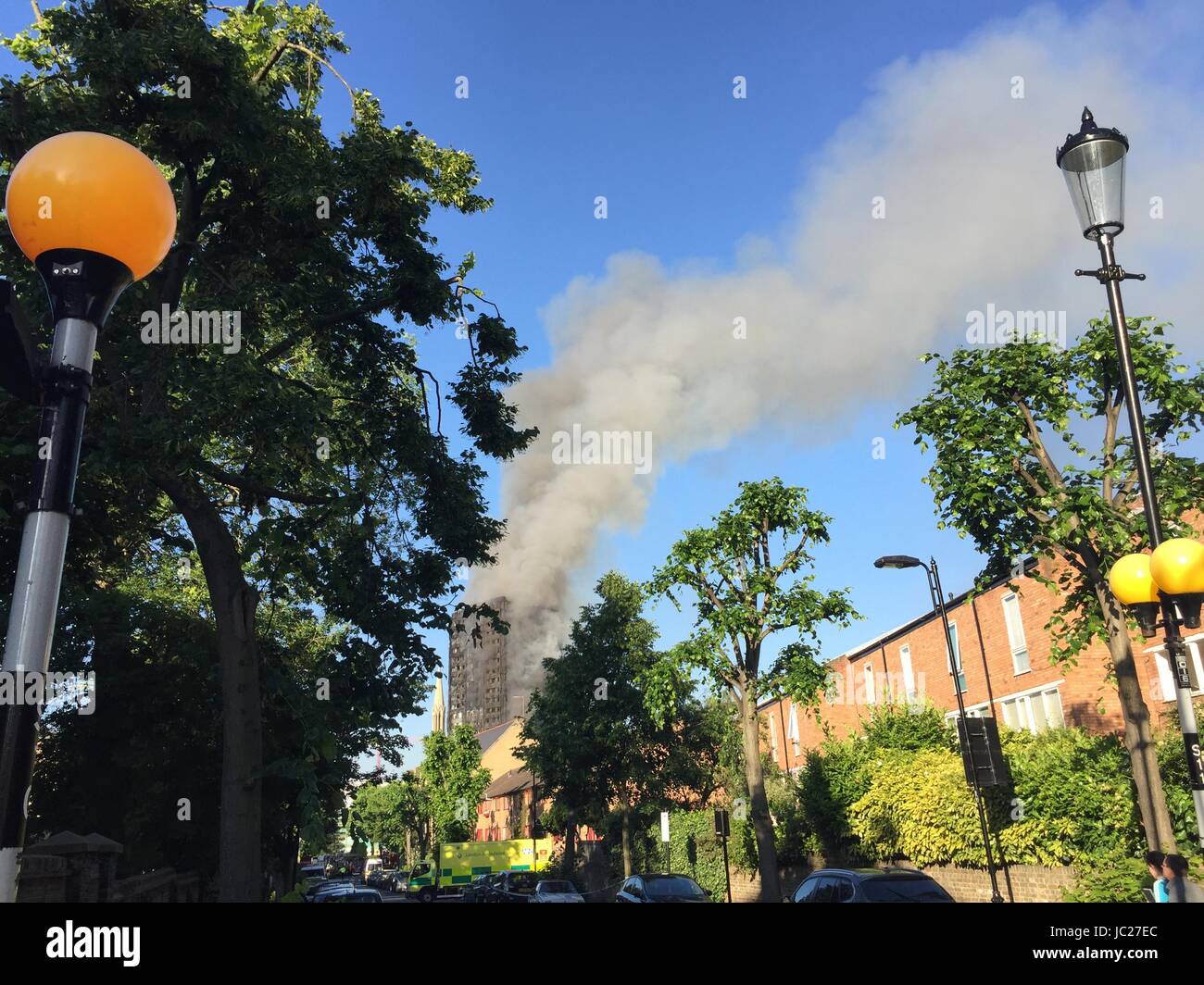 Londra, Gran Bretagna. 14 Giugno, 2017. Il fumo aumenta da un blocco a torre come fiamme conquistino la costruzione in London, Gran Bretagna, 14 giugno 2017. A 27 piani di un edificio situato nel centro della città di Londra è stato in fiamme poiché le prime ore del mattino del 14 giugno. In base alle proprie informazioni, i vigili del fuoco ha distribuito 200 vigili del fuoco e 40 motori Fire a combattere le fiamme. Foto: Filippo Dethlefs/dpa/Alamy Live News Foto Stock