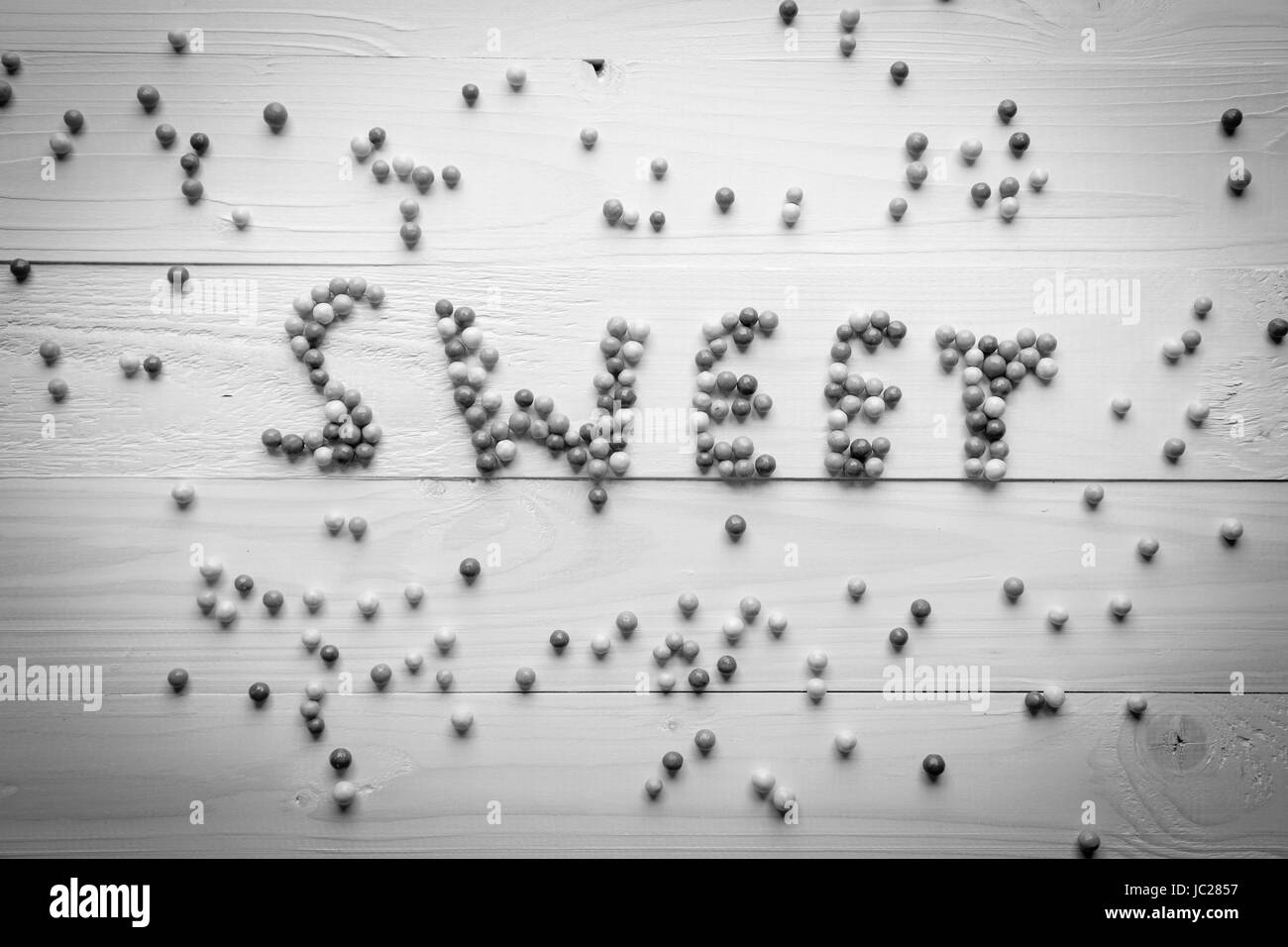Foto in bianco e nero di parola dolce scritto da little round caramelle Foto Stock