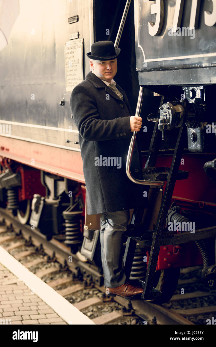 Tonica foto di un uomo in tuta retrò e cappello bowler arrivare in treno  vecchio Foto stock - Alamy