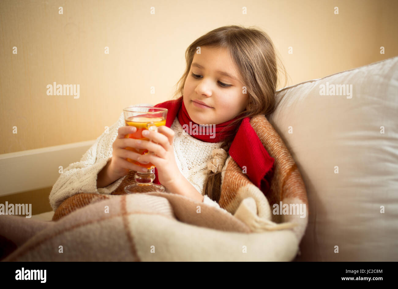 Ritratto di Cute girl got flu e azienda tazza di tè al posto letto Foto Stock