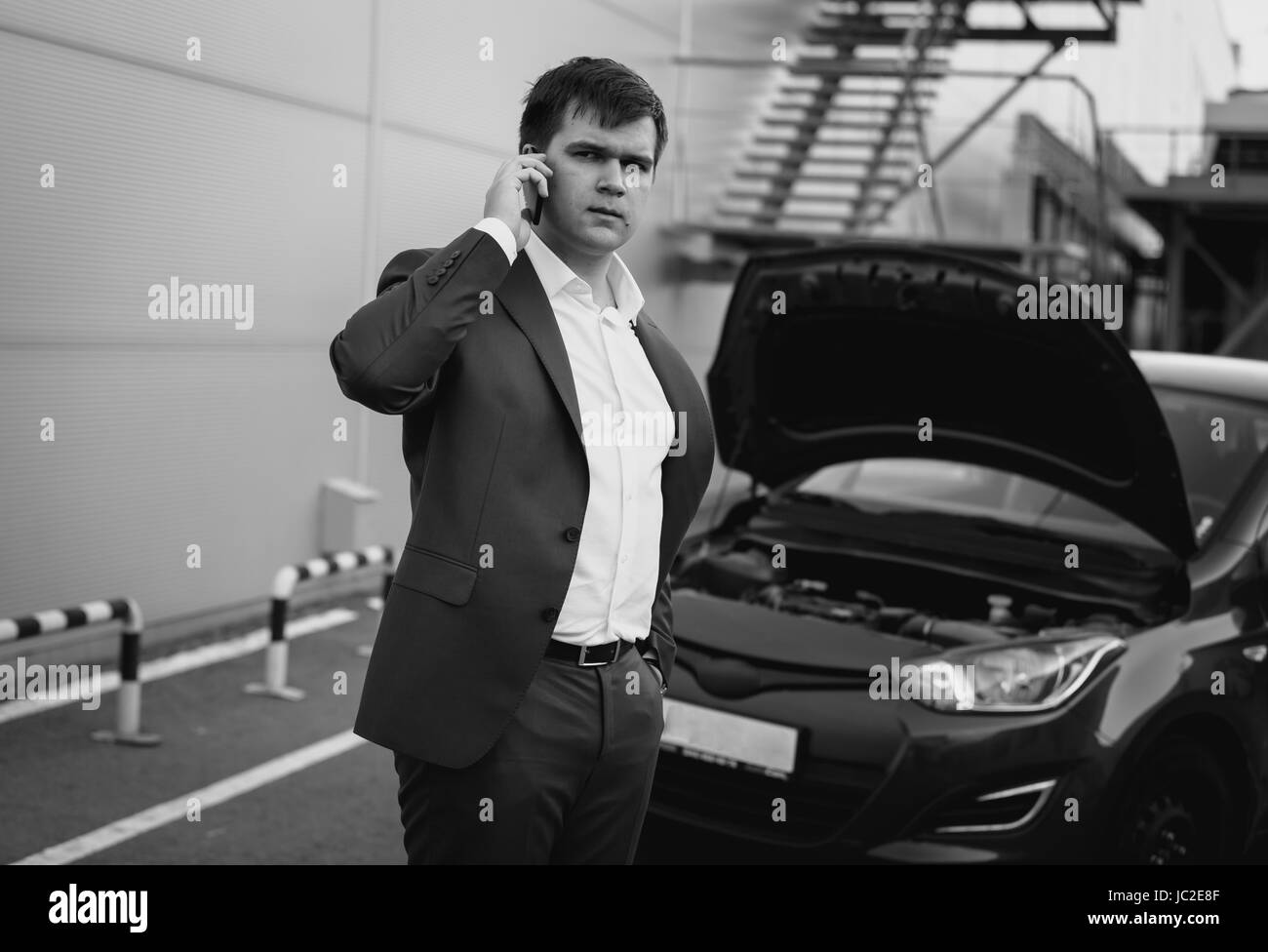 Bianco e nero ritratto di Giovane uomo chiamando dal telefono per auto di servizio Foto Stock