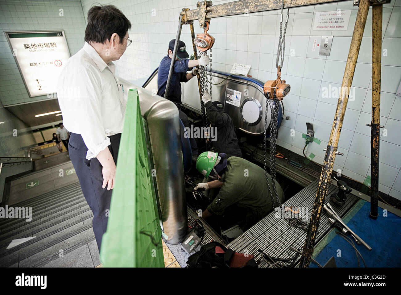 Tokyo, Giappone - 18 luglio 2011. Lavoratori edili sono la riparazione della scala mobile presso la stazione della metropolitana di Tokyo. Foto Stock