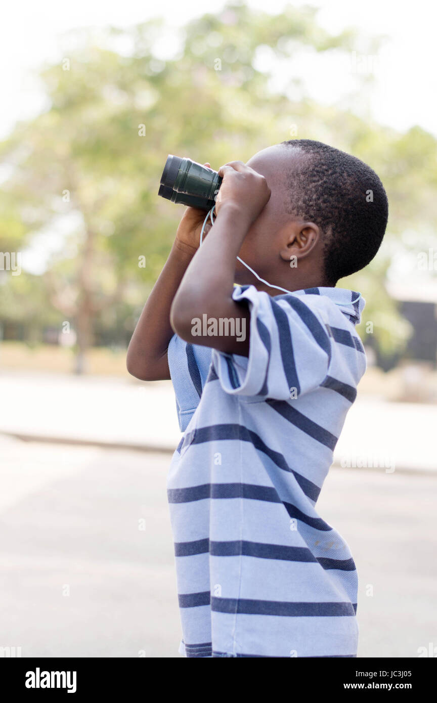 Bambino guarda attraverso il binocolo per cercare il suo marchio Foto stock  - Alamy