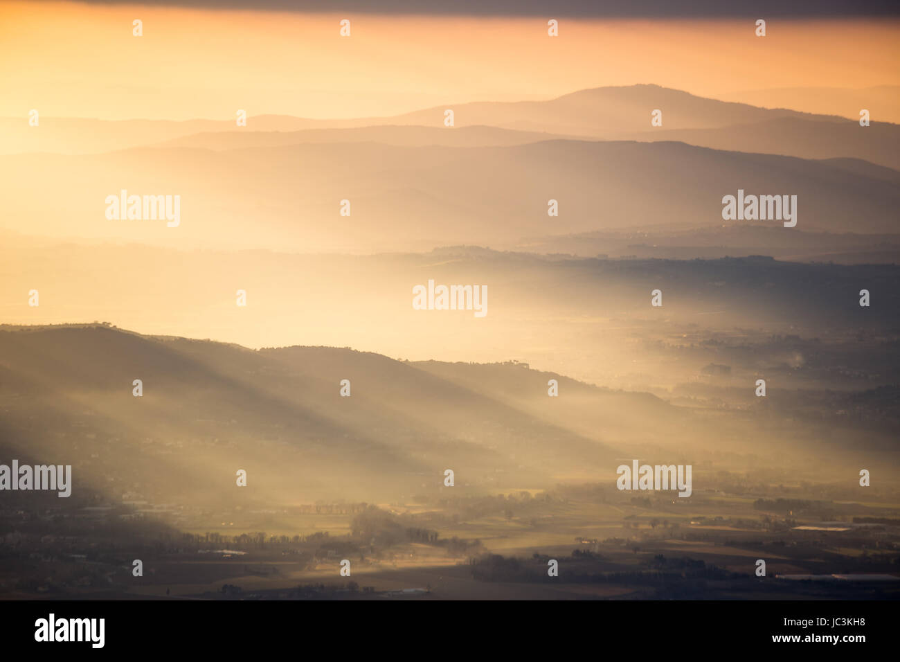 Raggi di sole su montagne al tramonto Foto Stock
