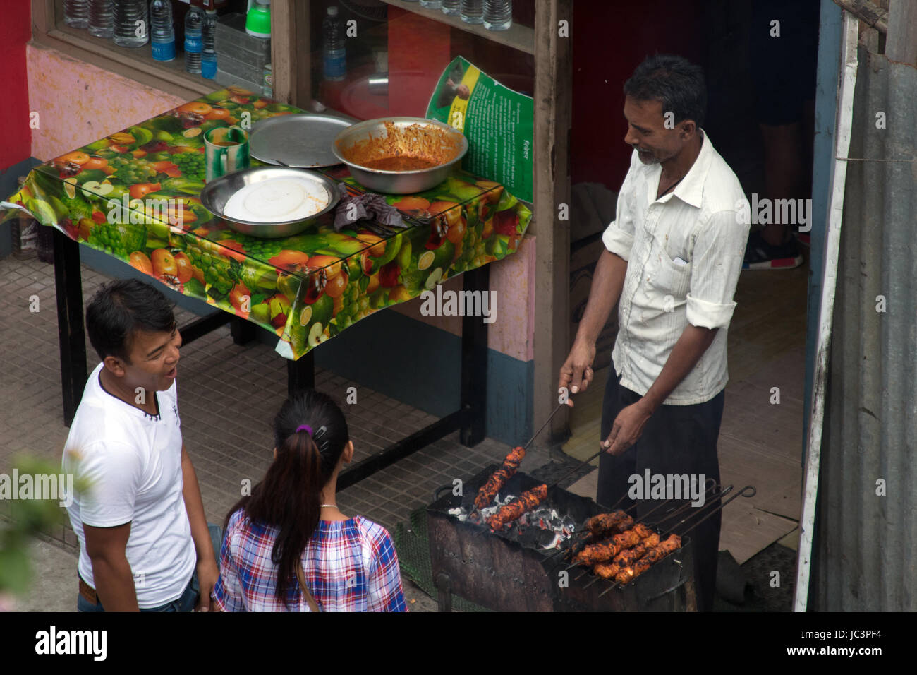 L'uomo la vendita di cibo di strada al di fuori di un cafe a Kalimpong West Bengal India Foto Stock