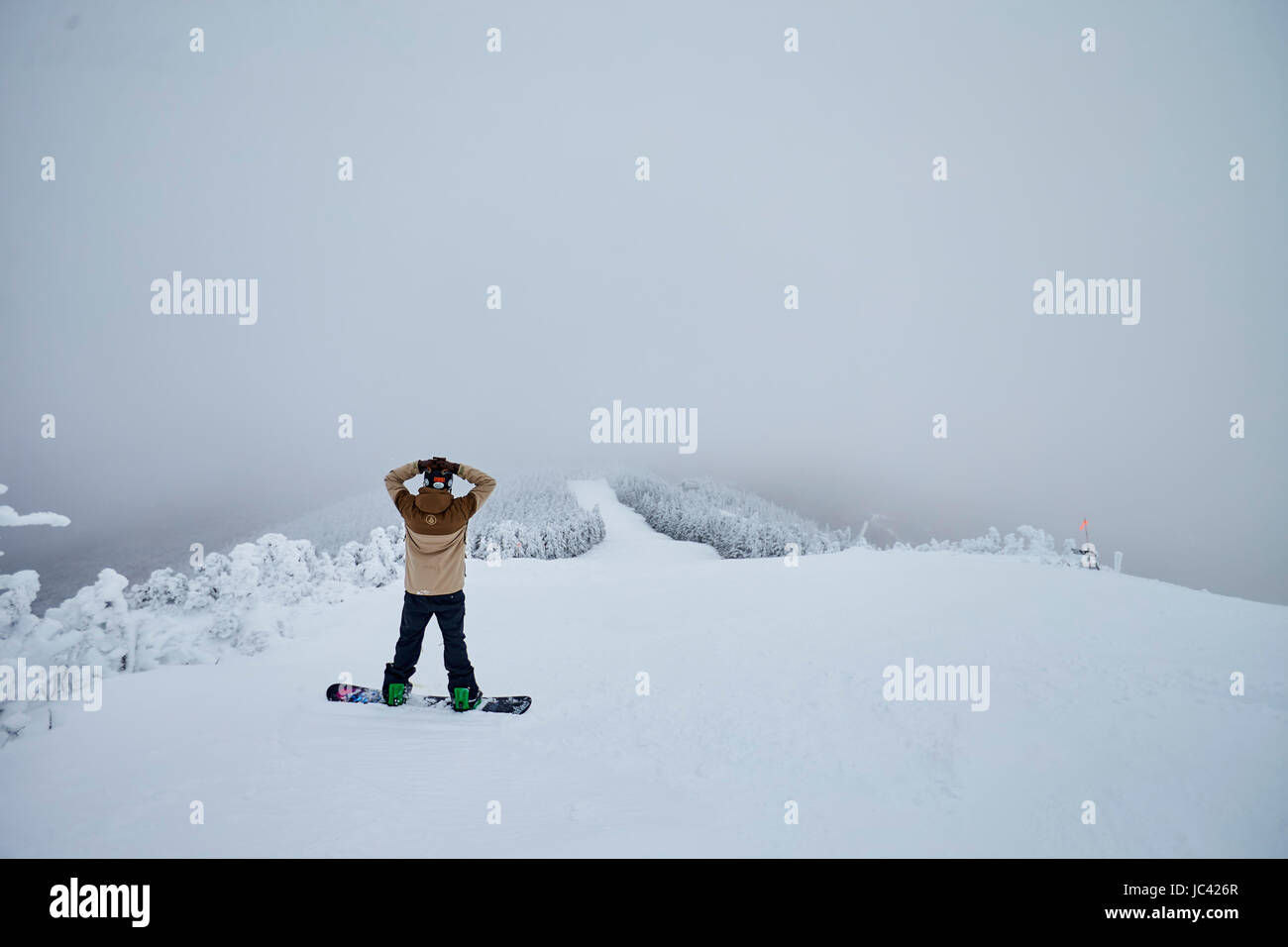 Uno snowboarder prende in polvere vista dalla cima del monte di Ellen a Sugarbush, VT. Foto Stock
