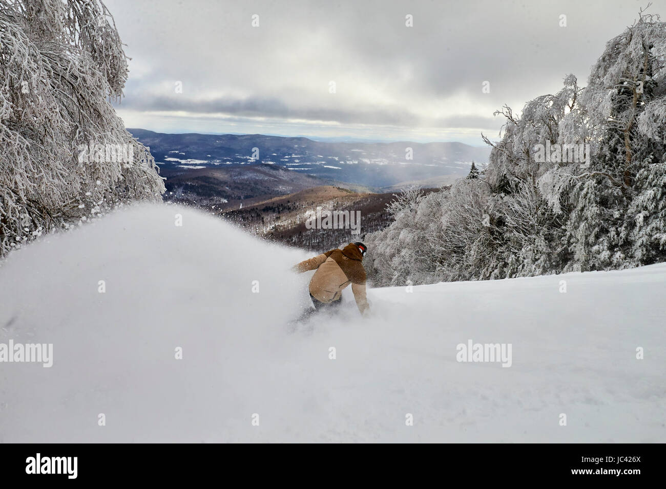 Uno snowboarder riducendo in polvere a inbounds Sugarbush, VT. Foto Stock