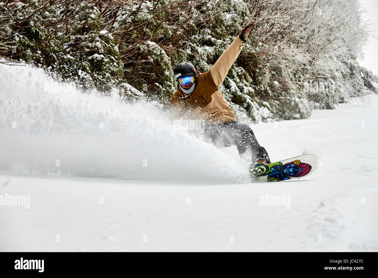 Uno snowboarder riducendo in polvere a inbounds Sugarbush, VT. Foto Stock