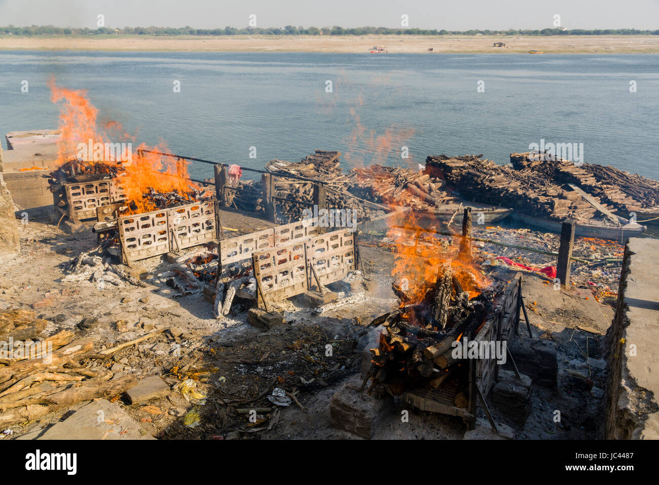 Fumo di cremato corpi morti è in aumento a manikarnika ghat presso il fiume sacro Gange nel sobborgo godowlia Foto Stock