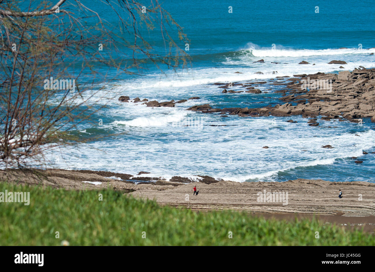 Camminando sulle rocce in Spiaggia di Itzurun, Paesi Baschi Foto Stock