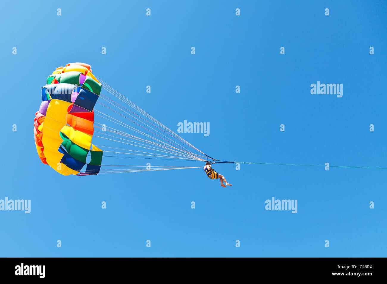 Donna parasailing sul paracadute nel cielo blu nel giorno di estate Foto Stock