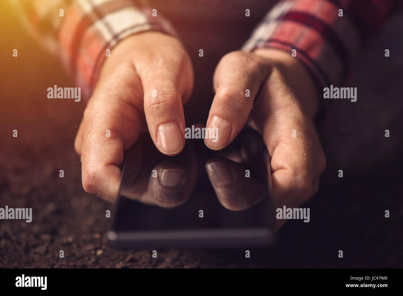 Stretta di mano utilizzando il telefono cellulare e il fuoco selettivo sul pollice Foto Stock