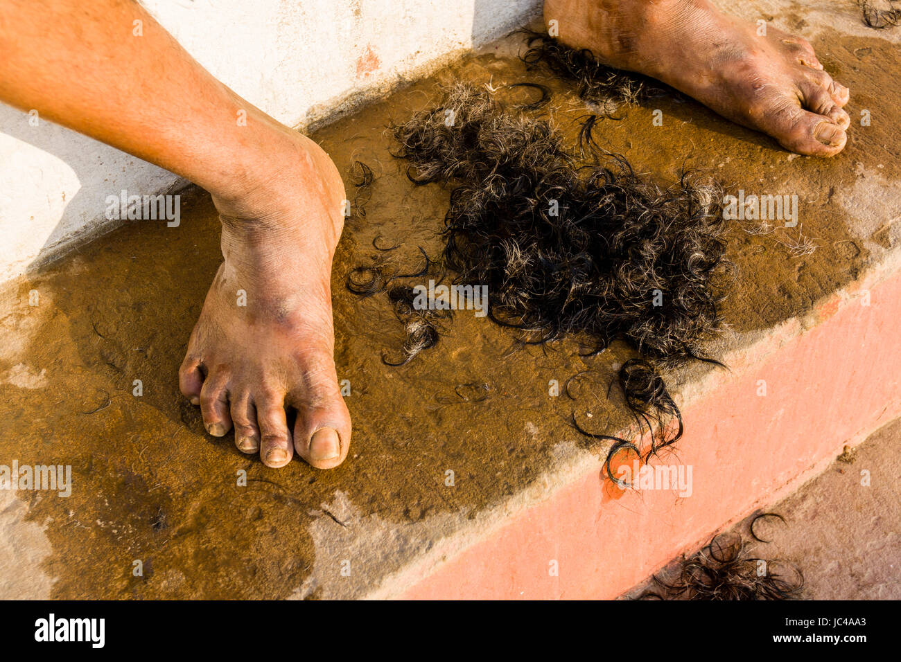 Un barbiere è la rasatura della testa di un pellegrino a dashashwamedh ghat, principale ghat, nel sobborgo godowlia Foto Stock