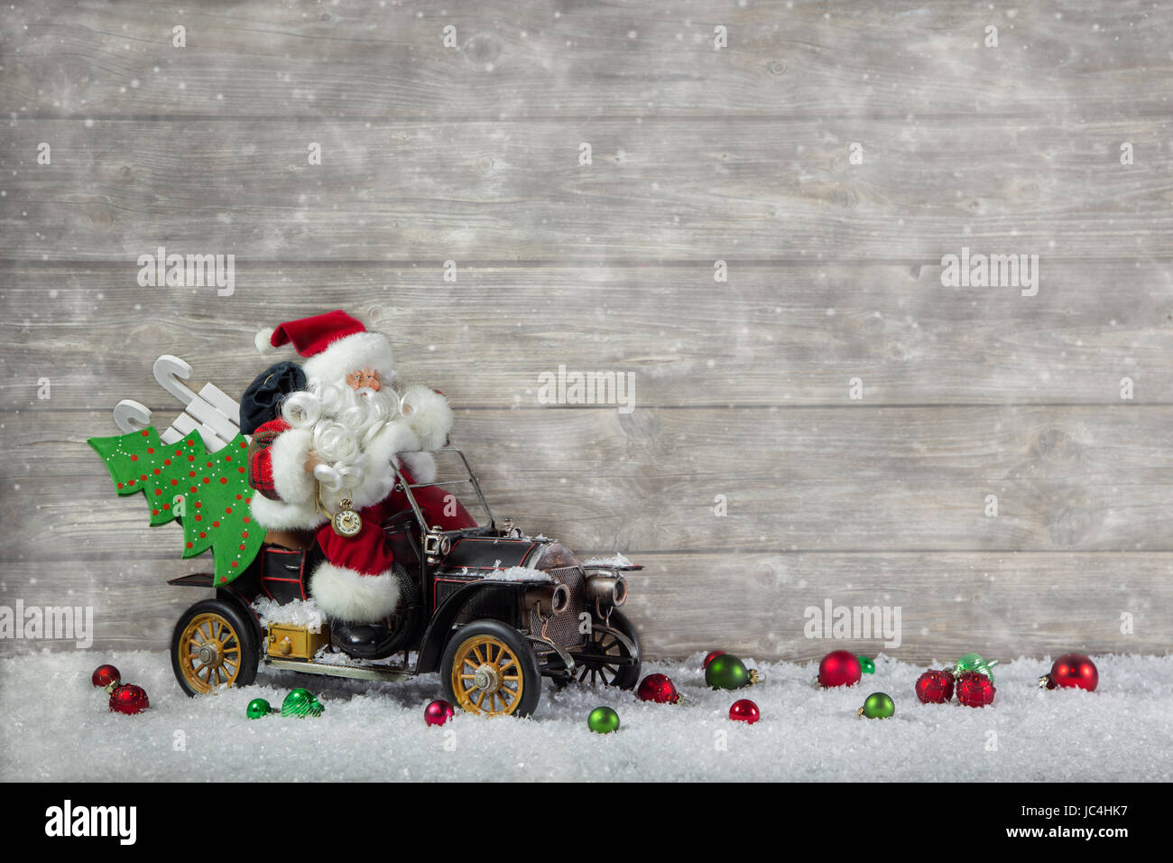 Santa Claus in fretta con la sua vettura: shopping di Natale lo stress. Decorazione con il vecchio vintage giocattoli su sfondo di legno. Foto Stock