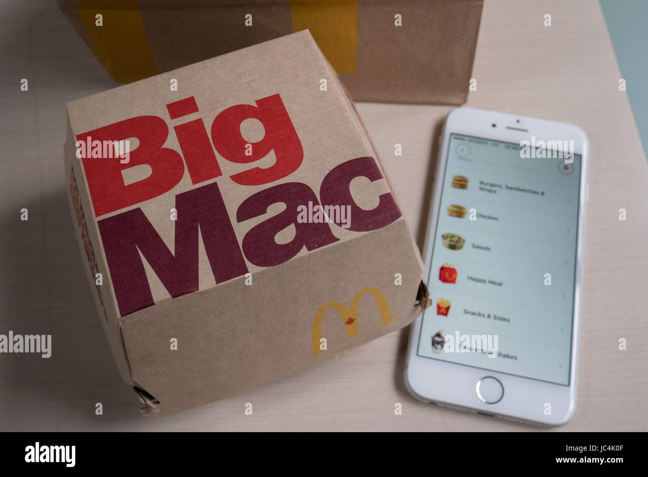 Un big mac accanto a iphone Foto Stock