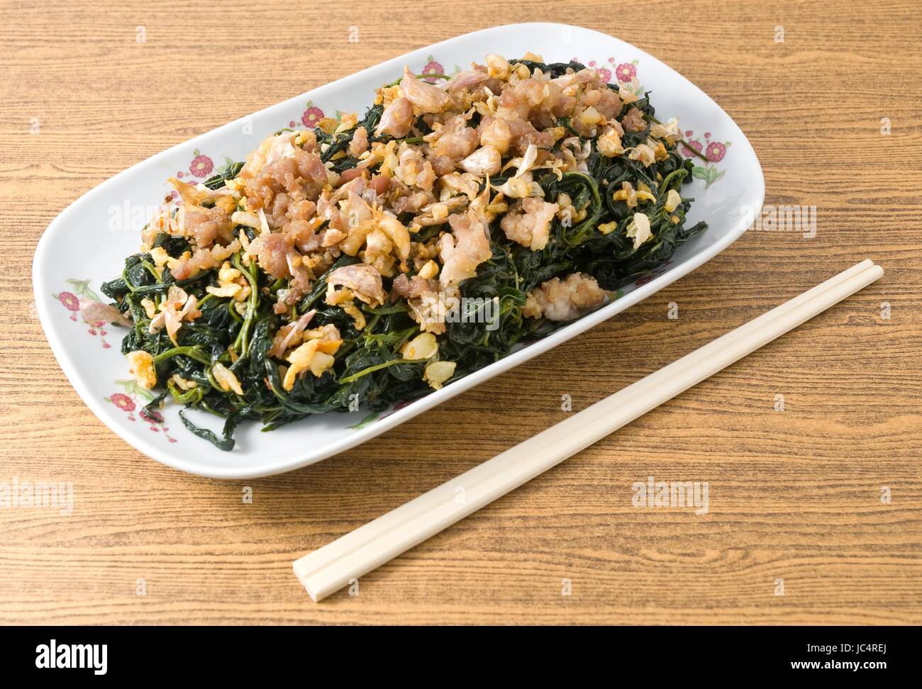 Cinese tradizionale cibo, piastra di mescolare fritto di foglie di iuta o Mulukhiyah foglie con carne macinata di maiale, Garlics e fermentati di soia. Foto Stock