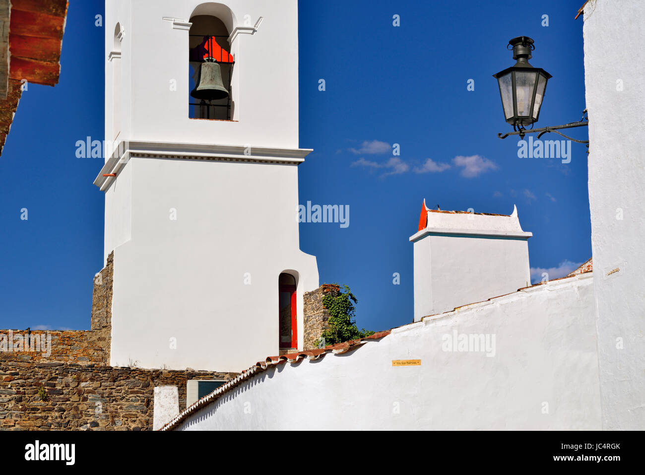 Torre campanaria, bianco lavato camino e via la luce con il blu del cielo Foto Stock