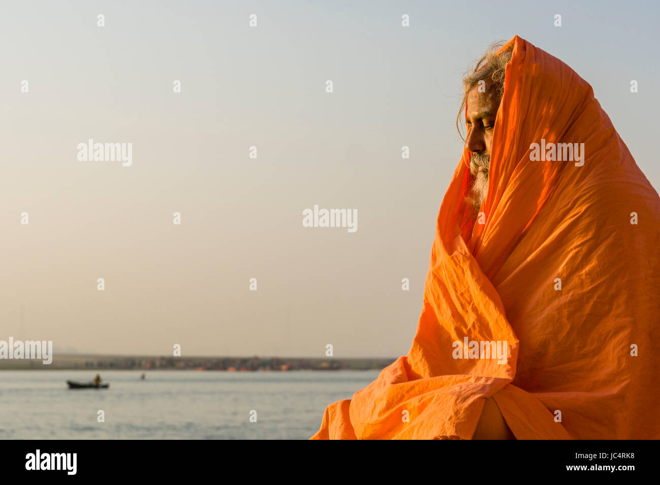 Un sadhu, uomo santo, è seduto e meditando su una piattaforma presso il fiume sacro Gange a dashashwamedh ghat, principale ghat, nel sobborgo godowlia Foto Stock