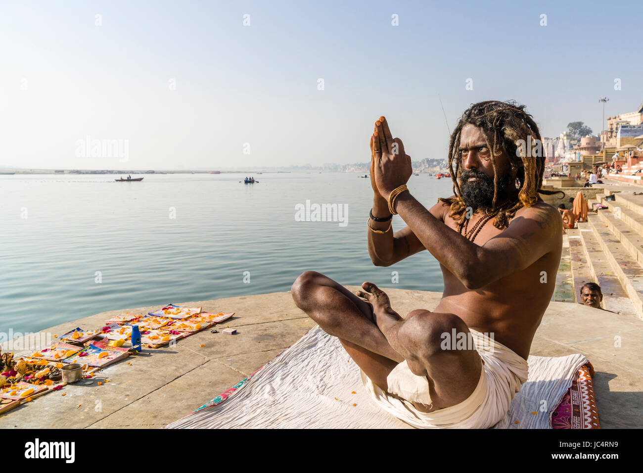 Un sadhu, uomo santo, è la pratica dello Yoga asana su una piattaforma presso il fiume sacro Gange a meer ghat nel sobborgo godowlia Foto Stock