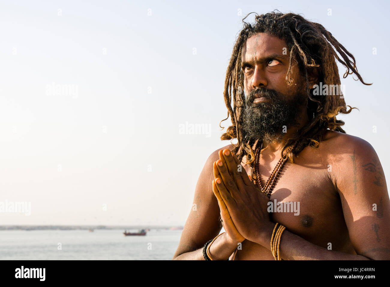 Un Sadhu, uomo santo, è la pratica di occhio lo Yoga asana su una piattaforma presso il fiume sacro Gange a Meer Ghat nel sobborgo Godowlia Foto Stock