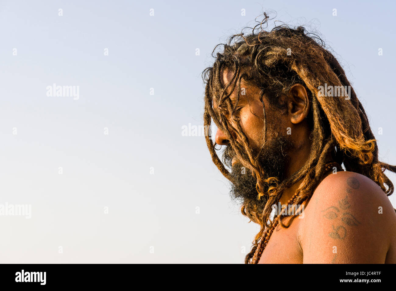 Un sadhu, uomo santo, è seduto e pregando su una piattaforma presso il fiume sacro Gange a meer ghat nel sobborgo godowlia Foto Stock
