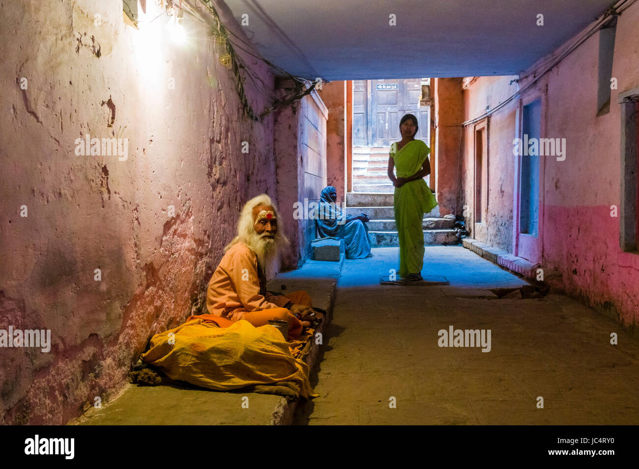 Un vecchio sadhu, uomo santo, è seduto e a mendicare in un passaggio sotterraneo nel sobborgo godowlia Foto Stock