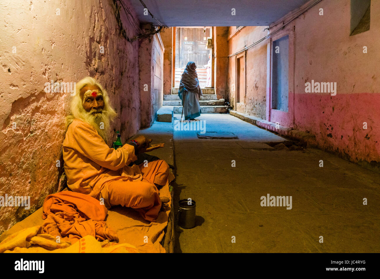 Un vecchio sadhu, uomo santo, è seduto e a mendicare in un passaggio sotterraneo nel sobborgo godowlia Foto Stock