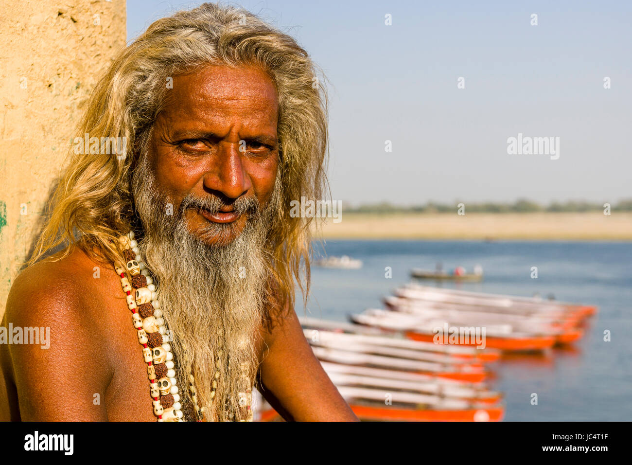 Ritratto di un sadhu, uomo santo, seduti su una piattaforma presso il fiume sacro Gange a dashashwamedh ghat, principale ghat, nel sobborgo godowlia Foto Stock