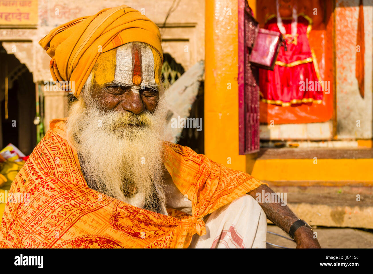 Ritratto di un sadhu, uomo santo, seduti su una piattaforma presso il fiume sacro Gange a dashashwamedh ghat, principale ghat, nel sobborgo godowlia Foto Stock