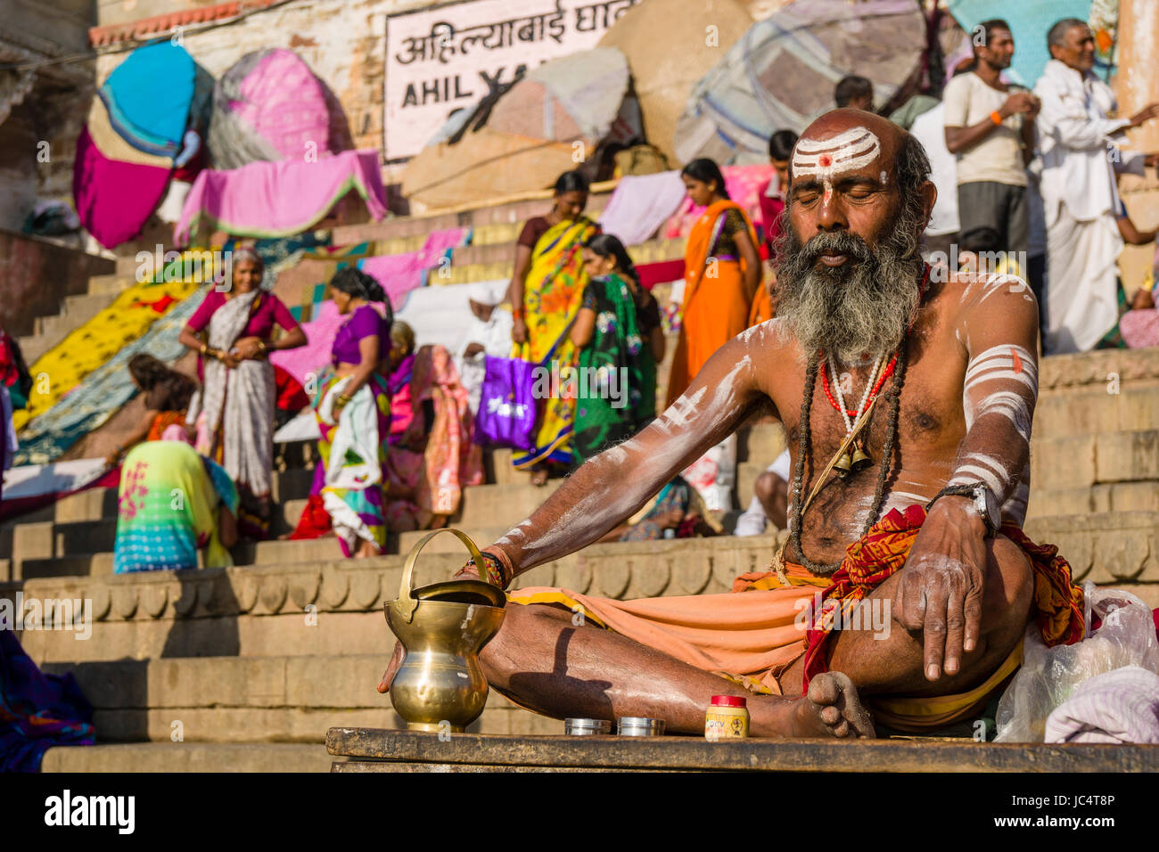 Ritratto di un sadhu, uomo santo, seduti su una piattaforma presso il fiume sacro Gange a dashashwamedh ghat, principale ghat, nel sobborgo godowlia Foto Stock