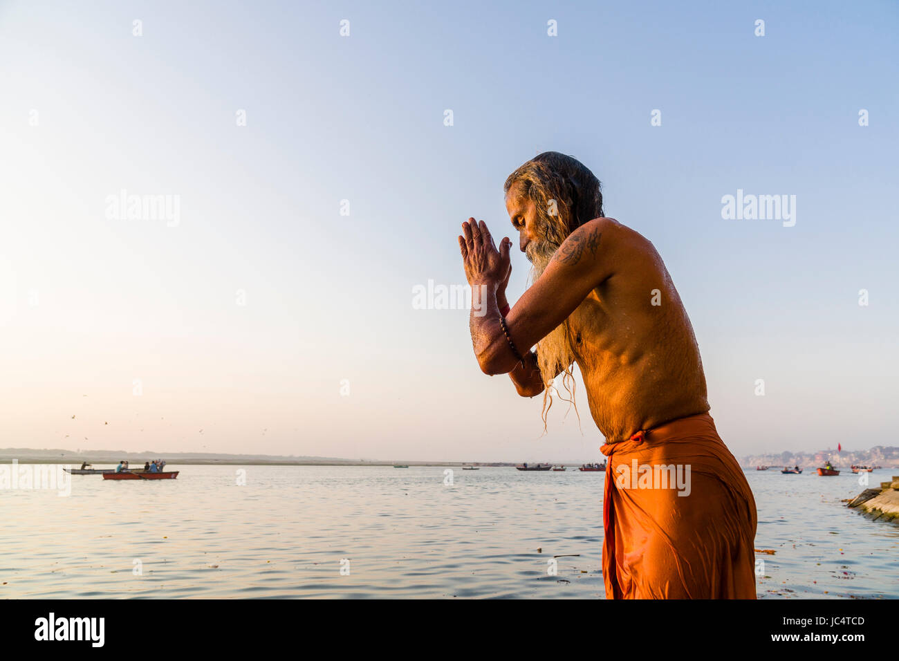 Un sadhu, uomo santo, è in piedi in acqua di fiume santo Ganges e pregando in lalita ghat nel sobborgo godowlia Foto Stock