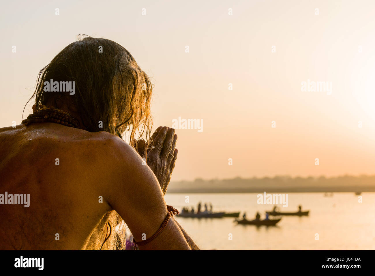 Un sadhu, uomo santo, è in piedi in acqua di fiume santo Ganges e pregando in lalita ghat nel sobborgo godowlia Foto Stock
