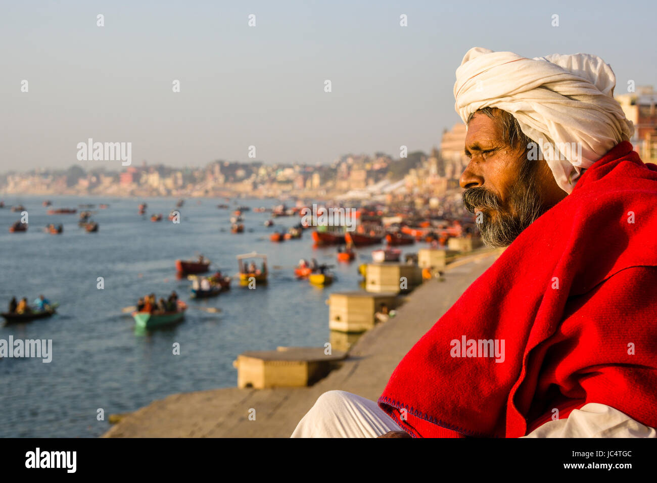 Ritratto di un sadhu, uomo santo, guardando attraverso il fiume sacro Gange a lalita ghat nel sobborgo godowlia Foto Stock