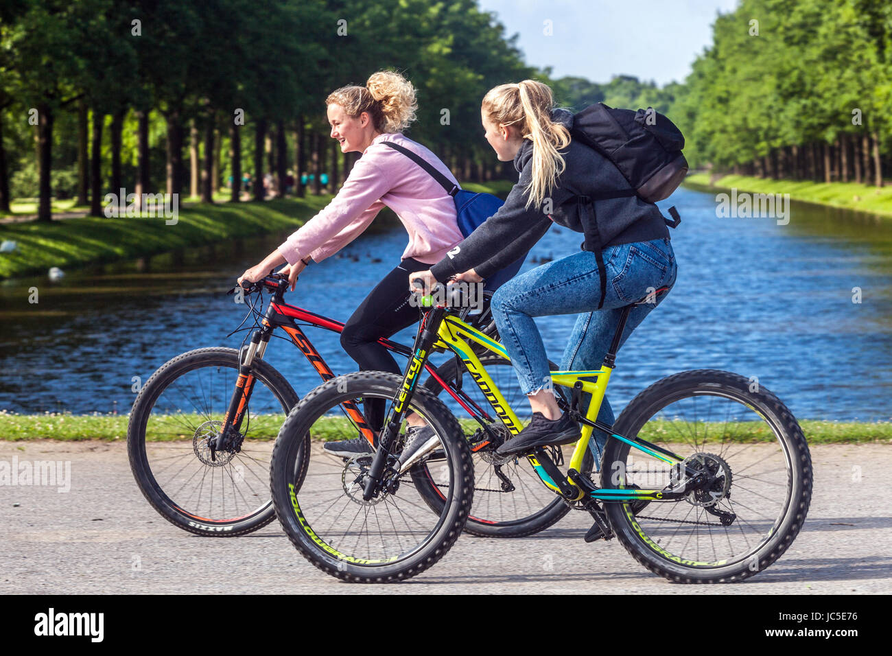 Due donne su una pista ciclabile nel giardino, Kassel, Germania ciclismo, Europa Foto Stock