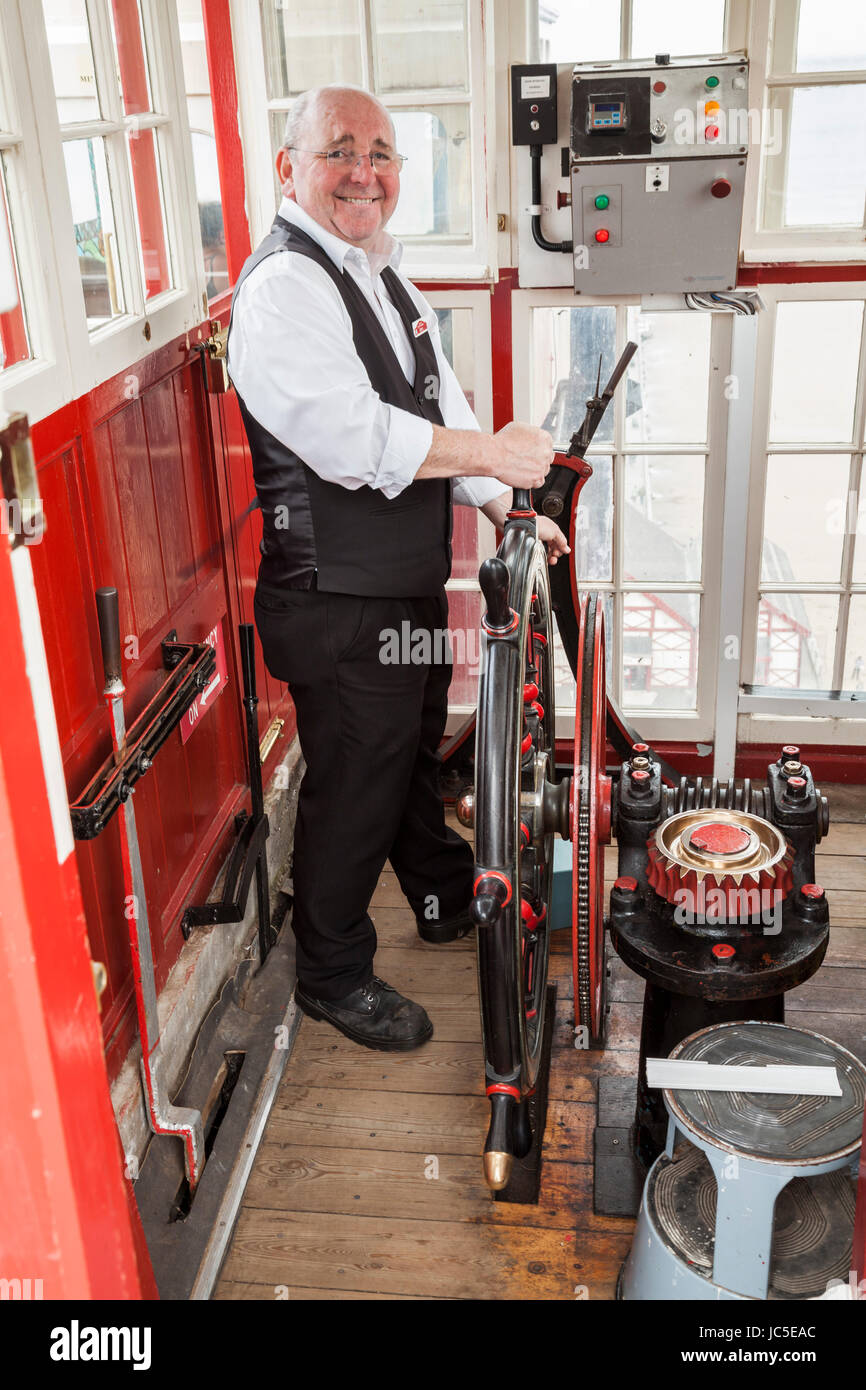 Il maschio di operatore della scogliera sollevare all interno della sua cabina a Saltburn dal mare, England, Regno Unito Foto Stock