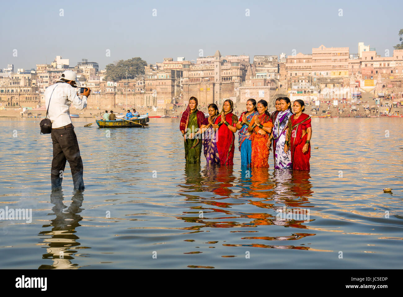Un fotografo è di scattare una foto di pellegrini tenendo bagno e pregare sui banchi di sabbia di fiume santo Ganges, panorama di Dashashwamedh Ghat, principale Gha Foto Stock