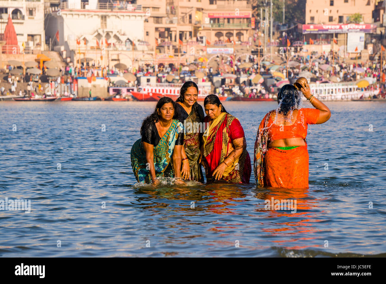 I pellegrini sono tenendo bagno e pregare sui banchi di sabbia di fiume santo Ganges, panorama di Dashashwamedh Ghat, principale Ghat, nella distanza Foto Stock