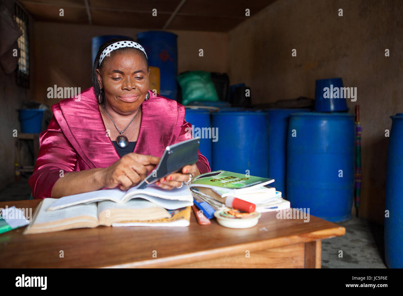 Un piccolo business donna facendo il suo account, Nigeria, Africa Foto Stock